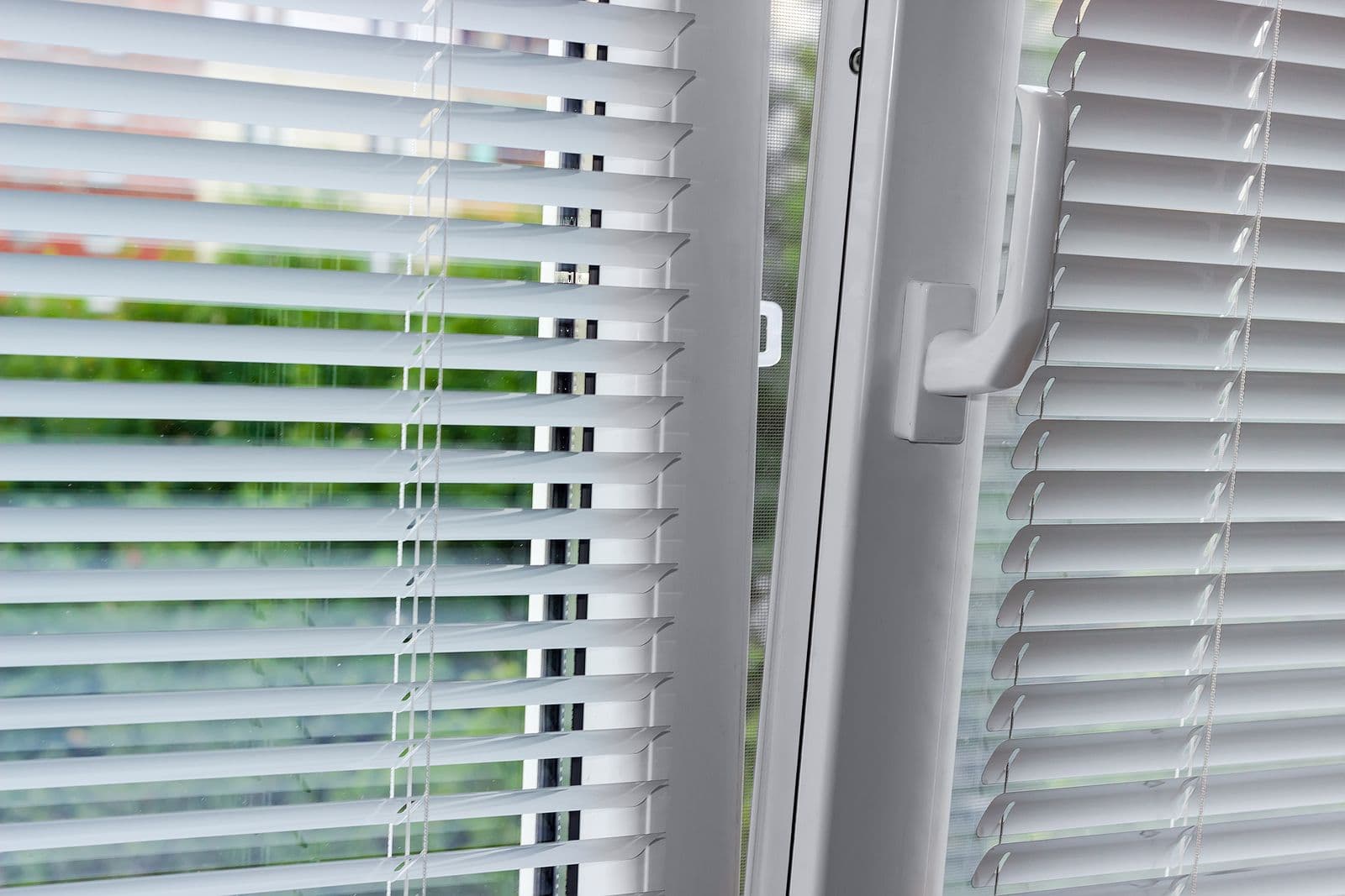 A European Tilt/Turn window with white trim and blinds.